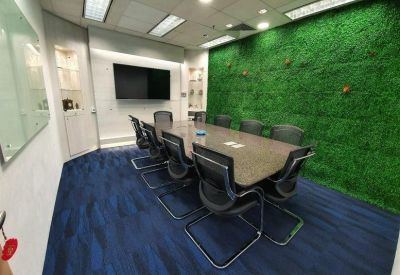 Sleek conference room with a green moss feature wall and blue patterned carpet.