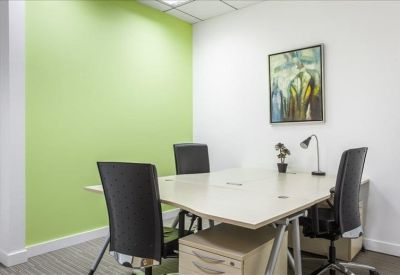 Bright private office featuring a lime green accent wall and a four-person desk setup.