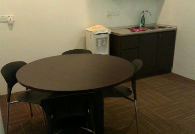 Communal kitchen area with a round dining table and water dispenser.