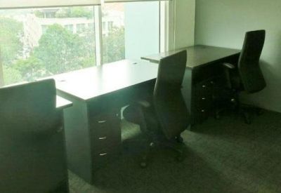 Bright office space with workstations facing a large window.