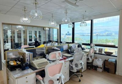 Bright office suite featuring desks, white ergonomic chairs, and a large window wall.