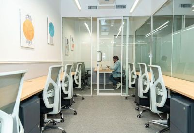 Private glass-walled office suites with ergonomic chairs and minimalist decor.