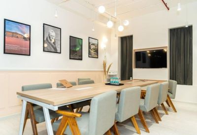 Professional meeting room featuring a light wood table and framed artwork on the wall.