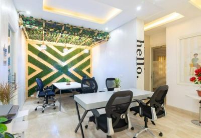 Meeting room with a geometric green feature wall and modern black office chairs.