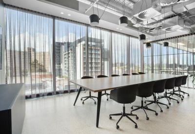 Spacious boardroom with a long wooden table and floor-to-ceiling windows.