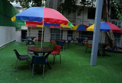 Outdoor seating area with artificial turf and colorful patio umbrellas.