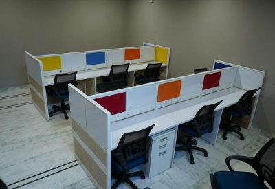 Modern workspace with white desks and colorful privacy dividers.