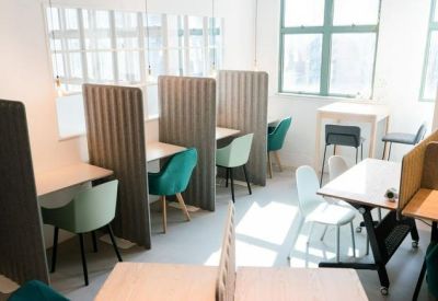 Modern workspace with tall acoustic privacy dividers and teal chairs.