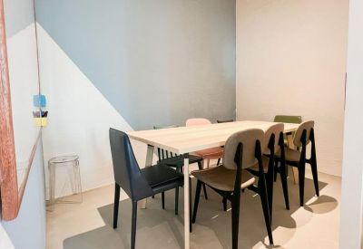 Private meeting room with a wooden table and cushioned chairs against a geometric wall.