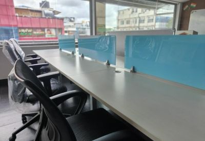 Modern workstations with ergonomic chairs and glass partitions overlooking the street.