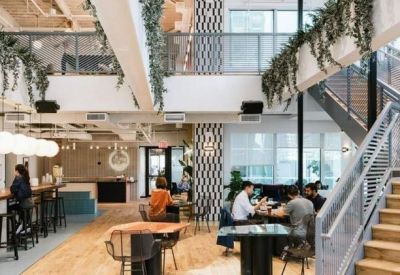 Spacious multi-level atrium with a cafe counter and wooden staircase.