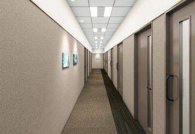 Long neutral-toned corridor with multiple private office doors and recessed ceiling lighting.