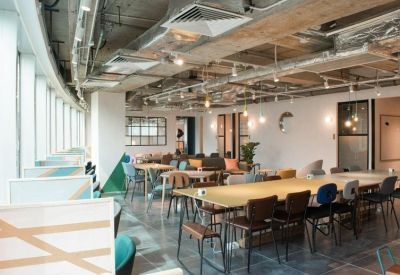 Large open-plan coworking space with various seating options and exposed ceilings.