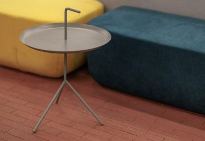 Breakout area with a minimalist tripod side table and colourful yellow and blue lounge seating.