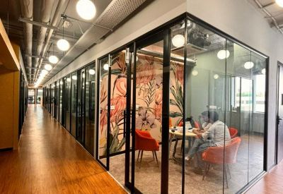 Corner office suite with wood-look flooring and glass partitions.