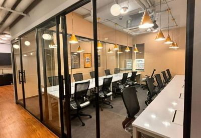 Meeting room with glass walls, white tables, and black chairs.