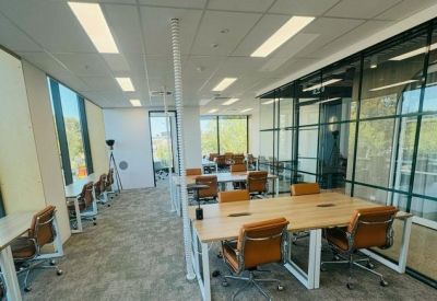 Bright open-plan office with timber desks and ergonomic chairs.