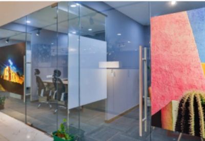 Glass-walled office suites featuring vibrant wall graphics and indoor plants.