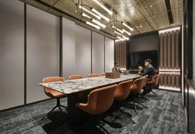 Professional meeting room with a marble table, tan leather chairs, and modern lighting.