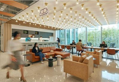 Spacious lounge area with orange leather sofas and a decorative light bulb ceiling.
