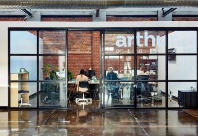 Glass-walled private office suite with brick accents and workstations.