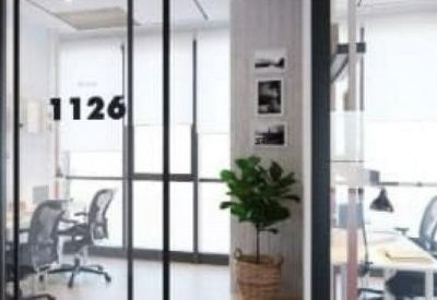 Glass-walled private offices with modern ergonomic chairs and numbered doors.