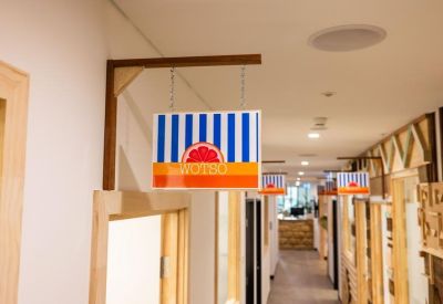 Hallway featuring hanging striped signage and light wood door frames.