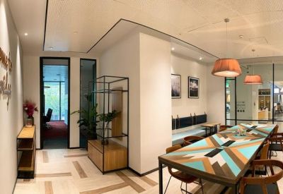 Reception area featuring a large patterned communal table and warm hanging pendant lights.