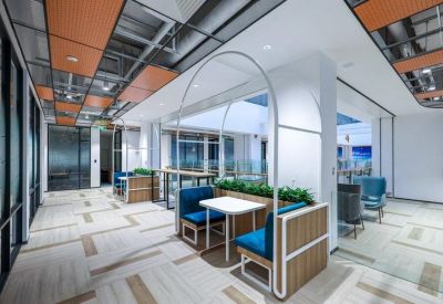 Modern semi-private booths with teal seating under white arch structures.