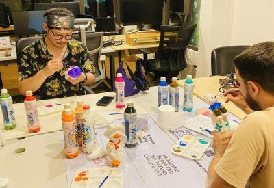 Staff engaging in a creative painting activity at a large table inside the office.