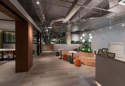 Reception and waiting area with a curved wooden bench and colorful ottomans.