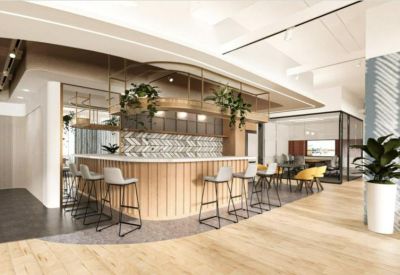Bright break area featuring a wooden bar counter with high stools and hanging plants.