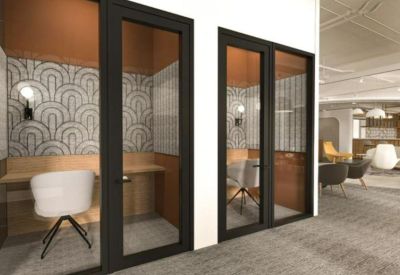 Private phone booths with patterned wallpaper and ergonomic seating.