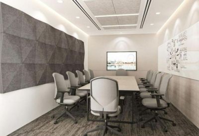 Spacious boardroom with a large table, grey chairs, and acoustic wall panels.