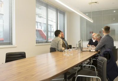 Meeting room with a large wooden table and professional seating.