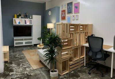 Cozy lounge area with wooden crate shelving, a flat-screen TV, and decorative wall art.