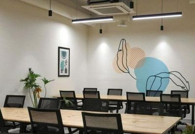 Large meeting room with long wooden tables, black mesh chairs, and a colorful wall mural.