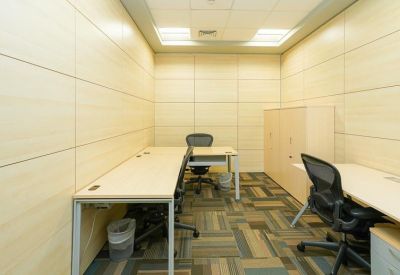 Private office suite with wood-paneled walls and three workstations with ergonomic chairs.
