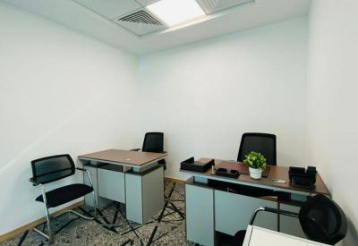 Private office suite for two people with dark wood desks and black mesh ergonomic chairs.