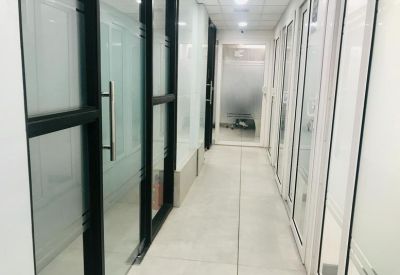 Long corridor with glass partitions and frosted privacy panels.