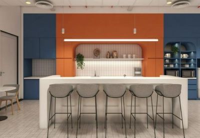 Modern kitchen and break area with orange and blue feature walls and a white island counter.