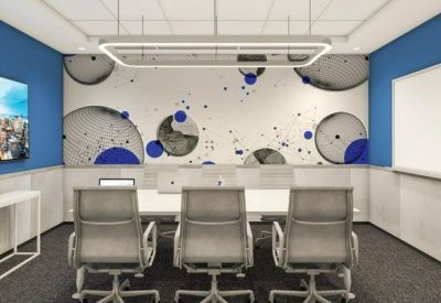 Meeting room with a white conference table, gray chairs, and a creative blue and white wall mural.