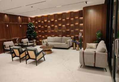 Lounge area featuring tan sofas and a textured wood-panelled accent wall.