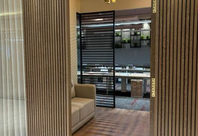 Wooden slatted entrance door opening into a modern office suite.