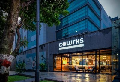 Exterior view of the glass-facade building at RMZ Infinity, Tower B on Old Madras Road.