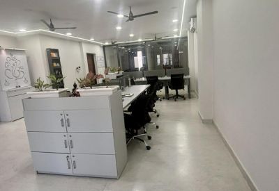Brightly lit office corridor with white filing cabinets and integrated linear ceiling lights.