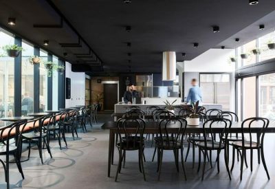 Chic lounge area with dark walls, wooden tables, and a central service counter.