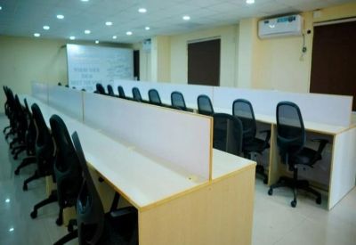 Bright coworking area with long workstations and divider panels.