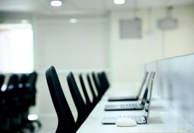 Close-up of modern laptops on a white desk in a bright office environment.