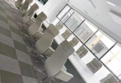 Conference room with a long table and high-back chairs.